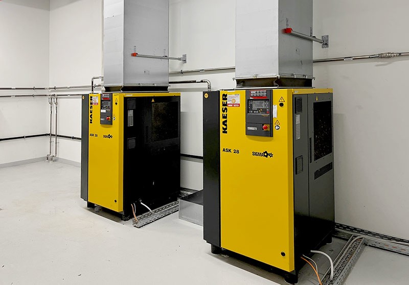 Zwei Kompressoren mit Abluftkanälen in einer Technikzentrale